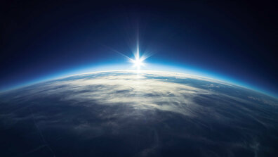 Ausschnitt der Erdansicht aus dem Weltall mit aufgehender Sonne.