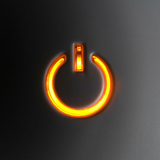 Power-Knopf Orange leuchtender Power-Knopf vor schwarzem Hintergrund