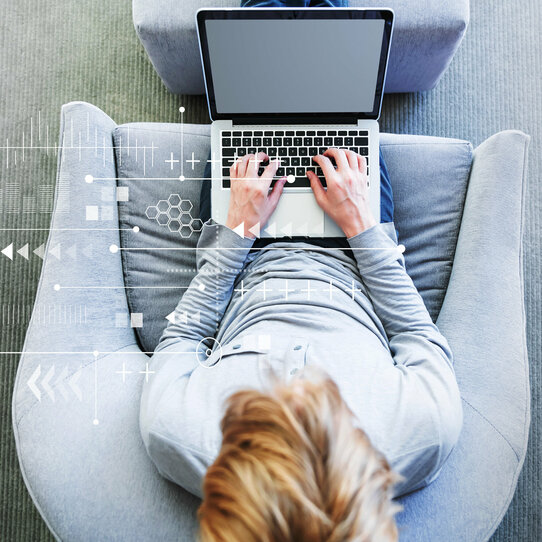 Cloud-Computing mit einem Mann mit einem Laptop in einem modernen grauen Sessel