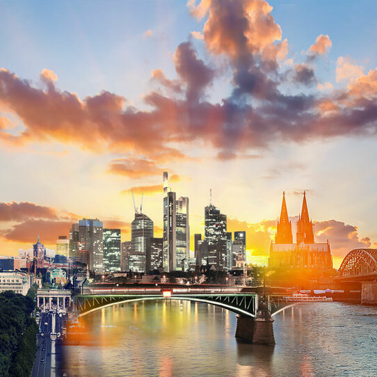 Skylines von Berlin, Frankfurt und Köln in einem Bild vor einem Sonnenuntergang.