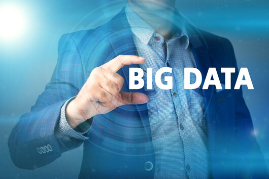 Mann fokussiert mit Hand den Schriftzug Big-Data Ein Mann hält den Schriftzug Big Data zwischen Daumen und Zeigefinger